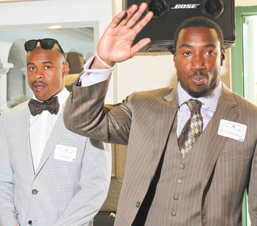 Warren Harding High graduate Mario Manninghan, right, waves, while former Ohio State receiver Ted Ginn Jr., left, looks on during a DeBartolo Foundation dinner Monday at Leo’s in Howland.