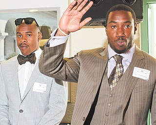 Warren Harding High graduate Mario Manninghan, right, waves, while former Ohio State receiver Ted Ginn Jr., left, looks on during a DeBartolo Foundation dinner Monday at Leo’s in Howland.
