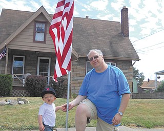 Little Bradley Miller Jr., son of Catherine Cercone and Bradley Miller, helps Tom Baringer, president of Struthers Rotary Club, put the finishing touches on the flag installment at his parents’ house. The Rotary club was busy over the weekend filling flag orders for the Fourth of July. The cost is $25, and the Rotary is still taking orders. Contact any member of Struthers Rotary.
