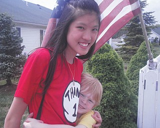In this photo from Terri Windsor of Poland, exchange student Pie Areepipatkul of Bangkok, Thailand, gets a hug from Ian Windsor, 5. While in the Valley, Pie lived with host families in Boardman and Columbiana and attended school.