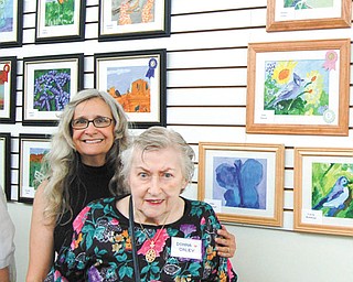 Donna Galey, front, of The Manor in Austintown, won best of show for her painting “Birds & Berries,” upper right corner. Galey is pictured with Suzanne Gray, YMCA art coordinator.