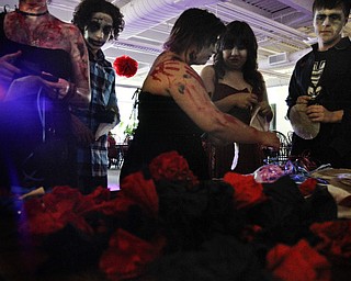 MADELYN P. HASTINGS..(left to right) Leah Evick, 15, of North Jackson, Ohio, Zachery Peck, 14, of Ashtabula, Ohio, Sarah Drogowski, 16, of Austintown, Ohio, Kristyn Wolf, 16, of Boardman, Ohio, and Tyler Grzyb, 16, of Boardman, Ohio create 'Body Part Boutonnieres' and 'Compost Corsages' at the Zombie Prom at the Poland Library.