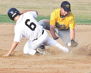 The Astro Falcons’ Jake Froats scrambles safely back to second as Toyota of Warren’s Tony Mehle bobbles the ball during a pick-off attempt during Monday’s Class B baseball playoff game at Cene Park in Struthers. Astro defeated Toyota, 2-0, to advance to the championship today against Creekside Fitness.