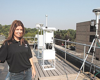 Administrator Tara Cioffi of the Mahoning-Trumbull Air Pollution Control Agency checks the air-quality monitoring equipment on the roof of the building next to Oakhill Renaissance Place at 345 Oak Hill Ave. in Youngstown.