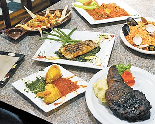 Station Square’s menu offers up a passionate helping of hearty flavor with organic ingredients. Clockwise, from top left, are Greek Shrimp, Pan Fried Veal sautéed with tomatoes and hot peppers, Risotto Mare e Monti, Charred Ribeye, Zucchini Blossoms and Homemade Blueberry Pie. At center, Blackened Alaskan Halibut over Italian Greens.