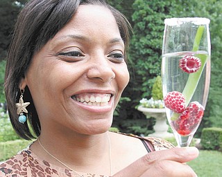 Kena Perkins, Springfield Grille’s service manager, holds a drink made with locally grown raspberries. She is involved with the menu that will be offered at the Friends of the Fellows Riverside Gardens’ “Sugar Beets Meet City Streets” Garden Party set for July 27. Photo by WILLIAM D. LEWIS | THE VINDICATOR