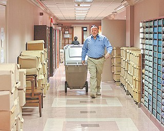 Scott Bates removes a container of documents from the Mahoning County Courthouse in downtown Youngstown. He is en route to a truck equipped to shred the documents outside the building. Protect-‘N-Shred, a paper shredding company based in Cortland, can destroy 2,000 to 2,500 pounds of documents in one hour, its president says.