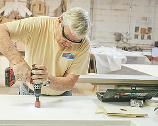 Working on a custom countertop, Rick Fitch drills slowly at Andre Silver’s Cabinet Makers on Market Street in Youngstown.