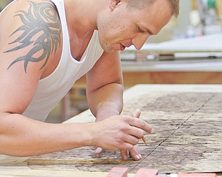 Silver’s son, Andre Jr., works on measuring a veneer, double-checking to make sure it matches the pattern.