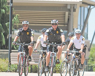 Officers, from left, Sgt. Dennis Godoy and Chief John Beshara of the Youngstown State University Police; second row, from left, Alki Santamas and Dave Moss, both of the Mahoning County Sheriff ’s office; and back row, Christian Hunter of Mill Creek MetroParks Police; unveiled YSU Police’s bike patrol unit Monday.