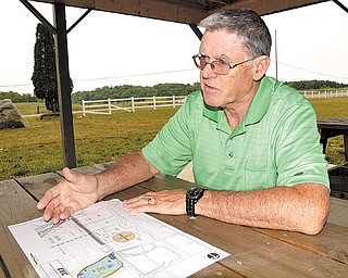 Mike Heher, park board president, shows off the blueprints for the enhancements that will include a drainage pipe.