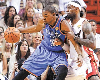 Oklahoma City Thunder forward Kevin Durant, left, works the ball against Miami Heat forward LeBron James during the first half of Game 5 of the NBA finals in Miami. Durant and James will team up for the USA in this summer’s Olympics.