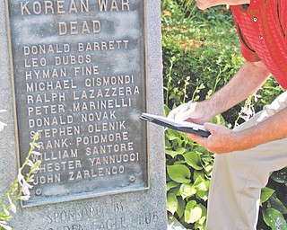 Jerry Nunziato, a retired criminal investigator from Youngstown, writes down names of soldiers from World War II and the Korean War that are listed on the Smoky Hollow Memorial so that he can do research on them.