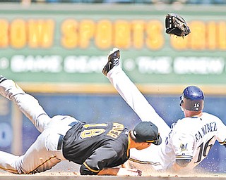 Pittsburgh Pirates’ Neil Walker, left, gets his glove kicked out of his hand by Milwaukee Brewers’ Aramis Ramirez as he steals second base during the sixth inning of a game Sunday in Milwaukee.