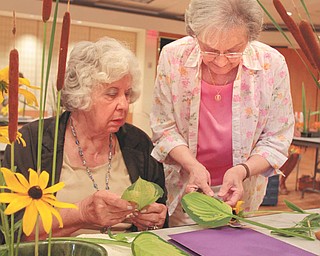 Shirley Winkler of Saxonburg, Pa., right, assists Pearl Marlos of Campbell as she creates a floral arrangement in the style of Ichiyo, one of numerous schools of Ikebana. Winkler has been teaching Japanese flower arranging for more than 30 years. Photo by: Robert K. Yosay | The Vindicator