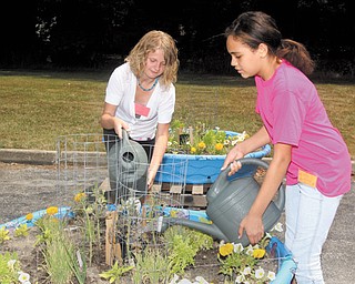 Ashlee Sedmond, left, and Jadyn Atwood, both of Boardman, work on their container garden at Pleasant Grove Presbyterian Church’s Camp Newport. Children who attend the Boardman camp participate in a variety of activities and are served lunch. Woodside Elementary in Austintown is host to a sister camp.