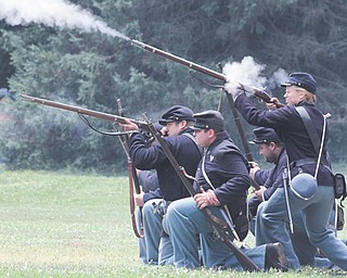 A group of Union soldiers fires muskets loaded with blanks during a battle scene during the Civil War re-enactment in Argus Park in Canfield. Re-enactors from both the Union and Confederate sides of the war took up camp in the park Friday through Sunday.