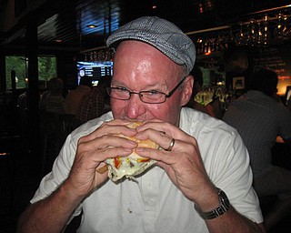 Scott Long takes a bite out of his Pittsburger at the Iron Bridge Inn.
