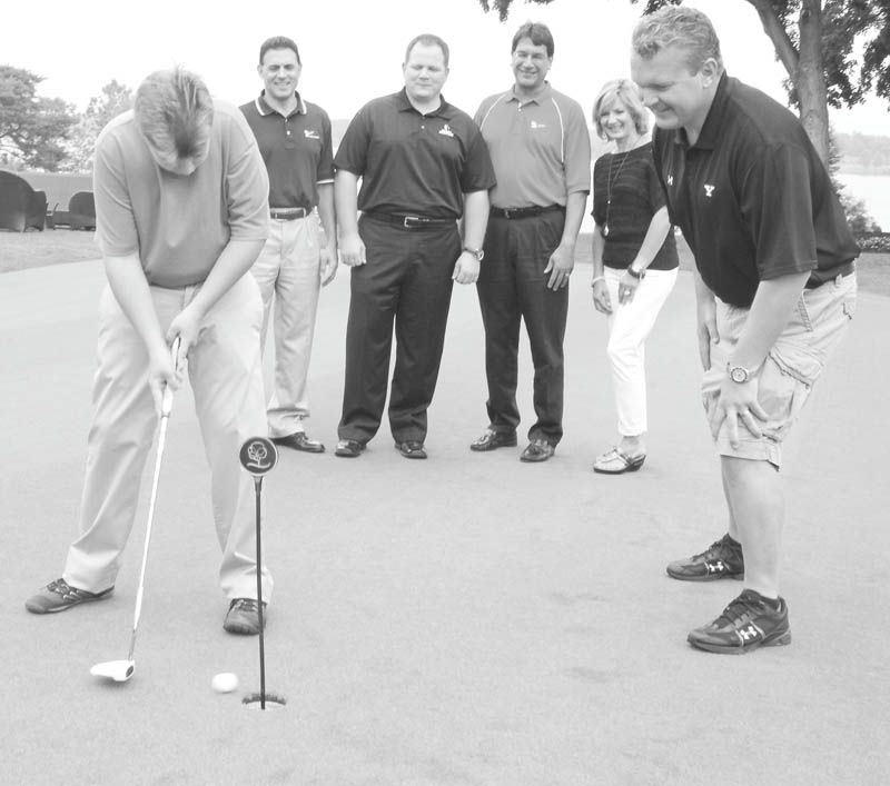 Chris Marchionda, 21, a graduate of the Rich Center For Autism, putts as YSU football coach Eric Wolford offers advice. In rear from left are Chris Colella of First National Bank, Rick Cook of Simon Roofing, Pete Asimakopoulos of First National Bank and Jackie Marchionda, mother of Chris. The Rich Center’s annual fundraiser, PAR Golf Outing, is scheduled for Aug. 27. Photo by WILLIAM D LEWIS | THE VINDICATOR