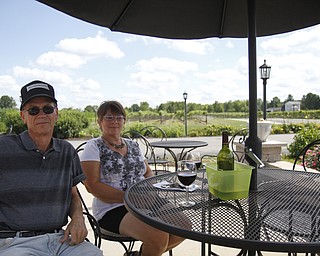 Theodore Bolan and Denise Cohol sit at the Mastropietro Winery in Berlin Center, Ohio and listen to the musical entertainment while enjoy a bottle of sweet red wine during the fourth annual rib festival. 