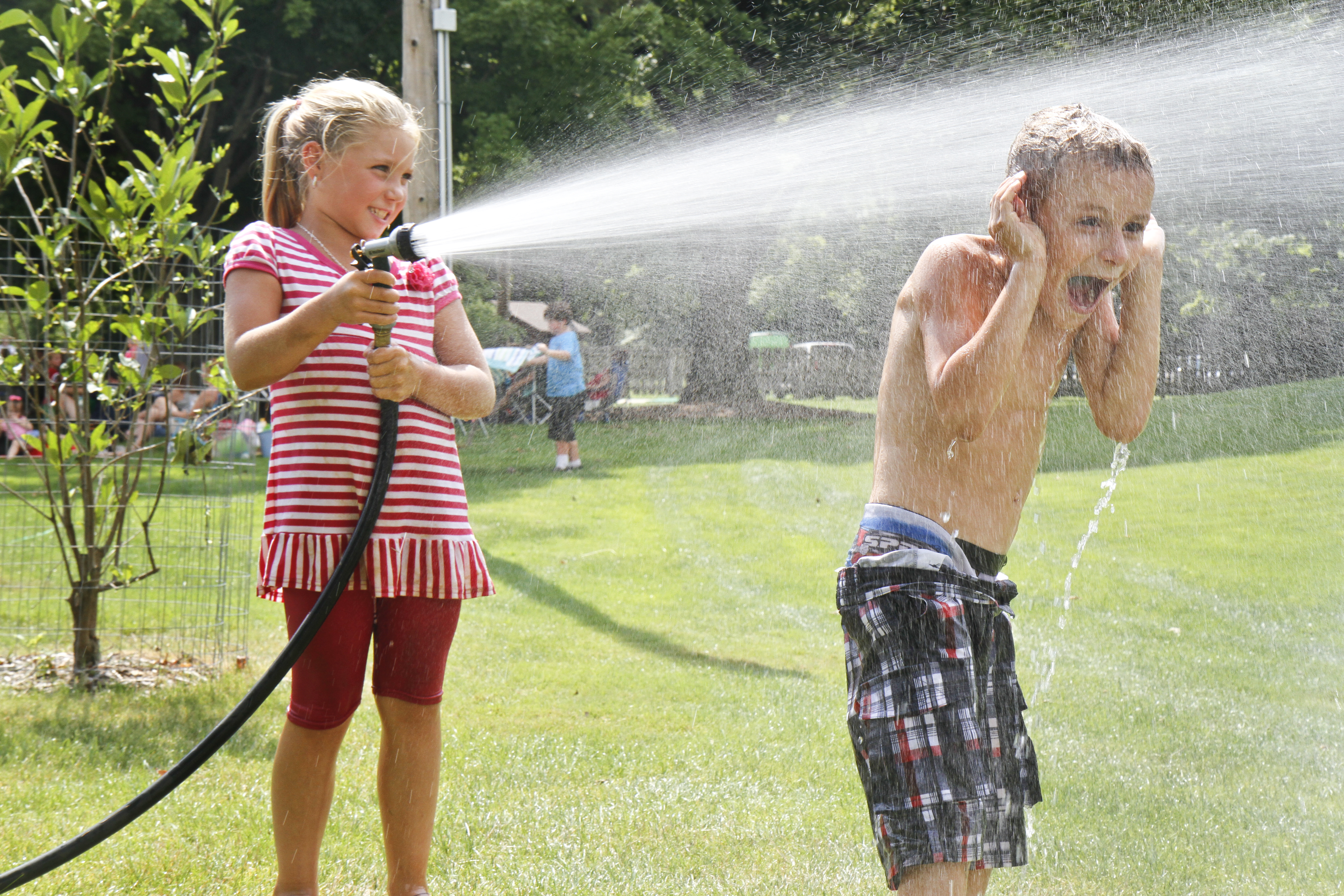 
Selena Rockenfelder, 7, sprays Stephen Strawderman, 6, with a hose at the sand sculpture contest at Mill Creek Park. Hoses and sand were provided for the participants. 