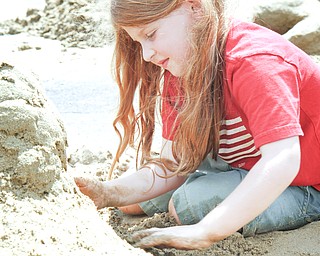 Olivia Lucia, 5, works on her sand castle at the sand sculpture contest at Mill Creek Park. 