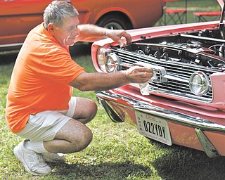 Sam Martuccio shines his daughter’s car at the Thunder in the Park car show in Woodland Park in McDonald. He restored the 1966 Mustang for his daughter, Lucua.