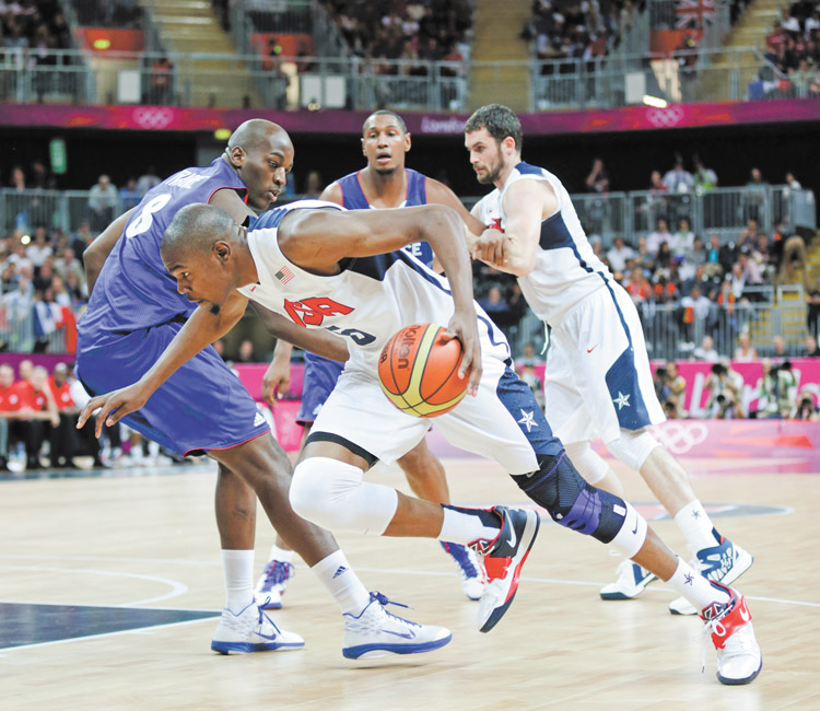 USA’s Kevin Durant drives to the basket past France’s Ali Traore during the first half of a preliminary men’s basketball game at the 2012 Summer Olympics on Sunday in London. The USA won 98-71.
