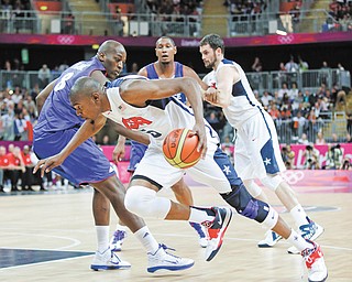 USA’s Kevin Durant drives to the basket past France’s Ali Traore during the first half of a preliminary men’s basketball game at the 2012 Summer Olympics on Sunday in London. The USA won 98-71.
