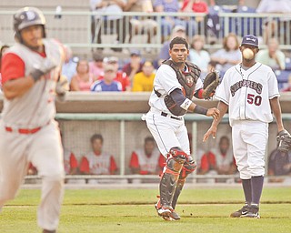 Mahoning Valley Scrappers pitcher Luis Morel watches as catcher Charlie Valerio (16) fi res the ball to fi rst base to get Brooklyn Cyclones base runner Alex Sanchez out during Monday’s New York-Penn League game at Eastwood Field, Niles. The Scrappers fell to the Cyclones, 5-1.