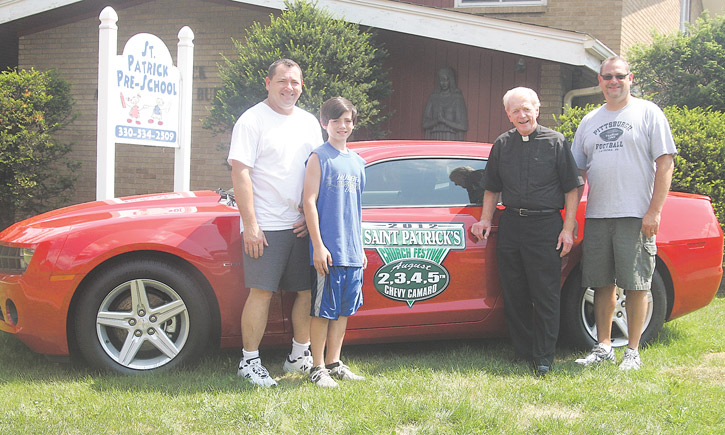 From left, Bill Fisher, St. Patrick’s festival chairman, Joey Fisher, the Rev. Tim O’Neill and Matt Fisher show off the new 2012 Chevy Camaro that will be given to a lucky winner Sunday night. St. Patrick’s annual festival runs Thursday through Sunday at the church in Hubbard.
