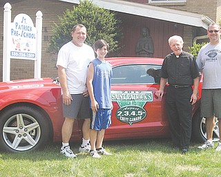 From left, Bill Fisher, St. Patrick’s festival chairman, Joey Fisher, the Rev. Tim O’Neill and Matt Fisher show off the new 2012 Chevy Camaro that will be given to a lucky winner Sunday night. St. Patrick’s annual festival runs Thursday through Sunday at the church in Hubbard.