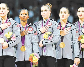 U.S. gymnasts Jordyn Wieber, left, Gabrielle Douglas, McKayla Maroney, Alexandra Raisman and Kyla Ross stand for their national anthem during the medal ceremony during the Artistic Gymnastic women’s team final at the 2012 Summer Olympics on Tuesday in London. Team U.S. won the gold.