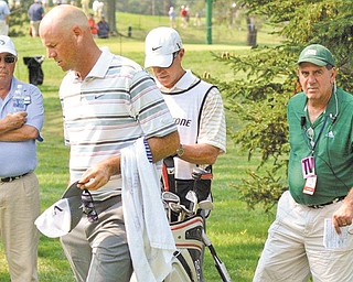 Phil Clacko of Coitsville, right, stands near PGA golfer Stewart Cink (holding hat) and Cink’s caddie during the 2011 Bridgestone Tournament in Akron when Clacko was Cink’s spotter.