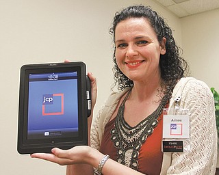 Aimee Reyes, store manager at J.C. Penney in Southern Park Mall, Boardman, displays an iPad checkout, which associates will use at points throughout the store. J.C. Penney has been in the process of once again reinventing itself by developing its “Fair and Square Program” and renovating stores to
create a marketplace with several outlets.