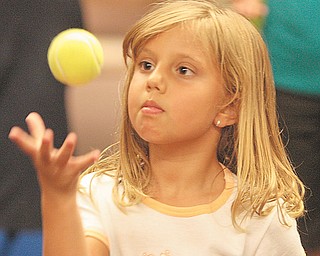 Gianna DeNiro, 6, of Boardman, is focused as she practices her juggling. Raz used the workshop to help the children learn about the laws of motion and gravity.