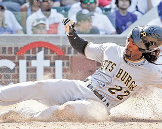 Pirates baserunner Andrew McCutchen slides in to home to score on a single by Garrett Jones during the eighth inning of Wednesday’s game against the Chicago Cubs at Wrigley Field. Pittsburgh scored five runs in the eighth to pummel the Cubs, 8-4.