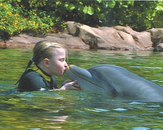 Grace Katherine Burchfield, daughter of Bethany Paulin of New Middletown, celebrates her 7th birthday with the dolphins at Discovery Cove in Florida.