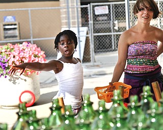 Anjela Taylor, 7, plays a ring toss game while Rebecca Mounts gives her careful instructions on the best way to win a prize.
