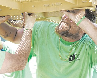 Jeff Crawford lifts a section of the play set in attempt to keep it level the the other sections during construction of Alex's Playground at Akron Children's Hospital in Boardman, Ohio. The workers constructing the play set are all volunteers.