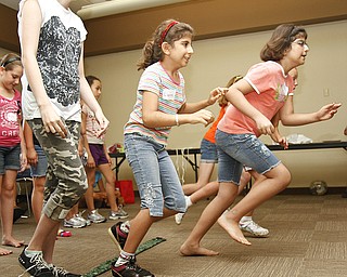 (L-R) Rita Sulebi, 12, Lianna Sulebi, 8, and Ranean Sulebi, 9, all of Boardman, Ohio, run to collect eggs without being hit by a ball. A couple different versions of the 'Live Pacman' game were played at the Boardman Library on August 9, 2012.