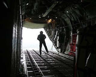 ROBERT K. YOSAY | THE VINDICATOR..payload exits the back of the C130 H to a location in the Ravenna Arsenal - as Sgt James Hudson Watches the parachute open - .-30-