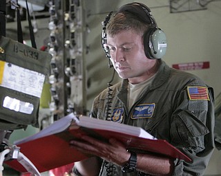 ROBERT K. YOSAY | THE VINDICATOR..SRA Marcus Watson checks a manifest in the plane - - .-30-
