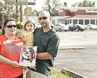 Brook, Marley, 2, and Paul Jillings of Boise, Idaho, hold a photo of their stolen English bulldog, Mabel, who was stolen from the travelers' van at Bob Evans on Belmont Avenue in Liberty.
