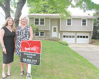The National Association of Home Builders has ranked the Youngstown metro area as the most-affordable market in which to buy a house in the second quarter. From left, Lynda Cononico and Yvonne Smith of Real Living Brokers Realty Group stand before their latest listing on Elm Trace Street in Austintown.