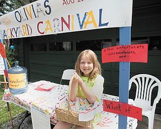 Olivia Helmick’s smile, as she sits at the booth announcing Olivia’s Backyard Carnival, seems to say “come on over” Sunday to her house at 8793 Woodland Road, just off Arrel Road and state Route 170 in Poland Township, and enjoy the fun and help homeless people at the same time.