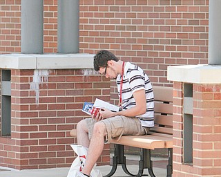 Jacob Schriner-Briggs of Liberty, a freshman at Youngstown State University, looks over his books and supplies in preparation for the start of the fall semester today.