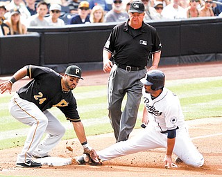 San Diego Padres’ Carlos Quentin, right, is tagged out by Pittsburgh Pirates third baseman Pedro Alvarez, left, as umpire Joe West moves in to make the call during the first inning of Wednesday’s game in San Diego.