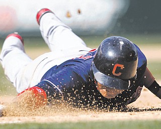 Cleveland Indians’ Shin-Soo Choo dives safely back to first base on a pick-off attempt in the eighth inning of Wednesday’s game against the Mariners in Seattle.
