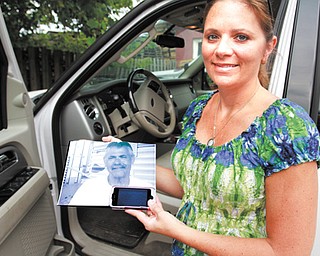 Tina Yanssens holds a picture of her father, Dave Muslovski, who was 55 when he was killed by a driver who was texting. Yanssens and her family lobbied for a texting-while-driving ban in Ohio. One targeting young drivers takes effect Friday.